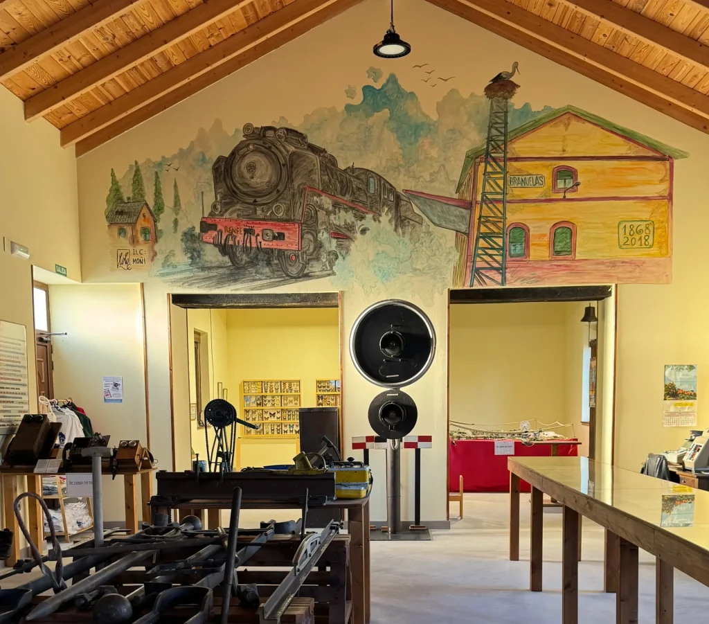 Mural de locomotora y herramientas ferroviarias en el Museo del Ferrocarril de Brañuelas